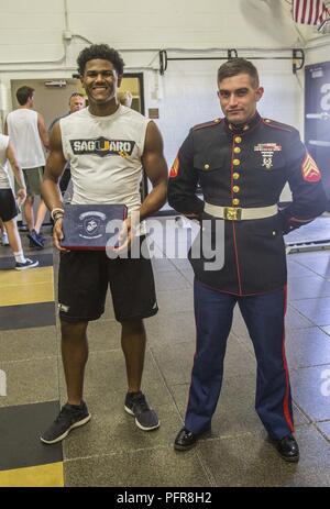 Sergeant David K. Randall, einem lokalen Personalvermittler mit einziehenden Station Phoenix, präsentiert die Semper Fi All-American Award zu Josia Jacobs bei Saguaro High School, Scottsdale, Ariz AMay 21, 2018. Jeder Amerikaner werden die Möglichkeit erhalten, einen Mentor ihrer Wahl von ihrer Schule einladen, Sport Team oder eine gemeinschaftliche Organisation der Veranstaltung neben Ihnen zu besuchen. Stockfoto