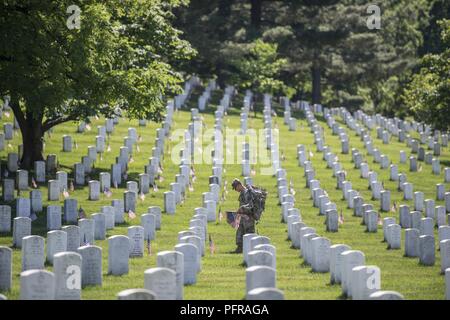 Ein Soldat aus der 3D-US-Infanterie Regiment (Die Alte Garde) Orte USA Fahnen auf Grabsteinen in Abschnitt 38 bei der Flaggen auf dem Arlington National Cemetery, Arlington, Virginia, 24. Mai 2018. Seit mehr als 60 Jahren Soldaten aus der alten Garde haben gefallenen Helden unserer Nation, indem sie US-Fahnen auf grabstätten für Service Mitglieder sowohl auf dem Arlington National Cemetery und die US-Soldaten" und "Flieger Home National Cemetery gerade vor dem Memorial Day Wochenende begraben geehrt. Innerhalb von vier Stunden, mehr als 1.000 Soldaten platziert 234,537 Flaggen vor jedem Grabstein und Columbarium und Nische w Stockfoto