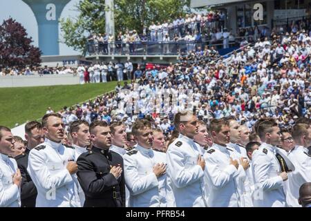 Neu gefördert US Marine Corps 2. Leutnants und U.S. Navy Fähnriche der US Naval Academy Klasse von 2018 legen sie ihre Hände über ihre Herzen für die US Naval Academy Song während ihrer Graduierung und Inbetriebnahme Zeremonie, Annapolis, MD., 25. Mai 2018 kämpfen. Die Klasse von 2018 graduierte 1.042 Midshipmen und wurden von den Damen und Herren Donald J. Trumpf, 45. Präsident der Vereinigten Staaten gerichtet. Stockfoto