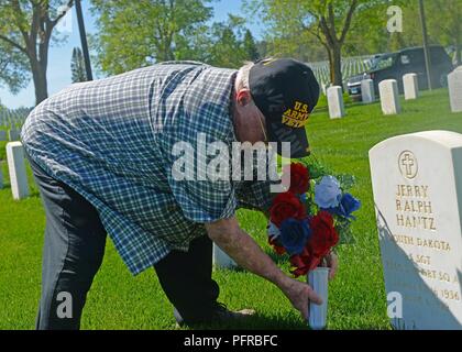 Jack Kantz legt Blumen am Grab seines Bruders während des Memorial Day Wochenende im Black Hills National Cemetery in der Nähe von Sturgis, S.D., 26. Mai 2018. Wenn ein Service Mitglied ist auf einem Friedhof interniert, die Zeremonie kann mit sieben - volley Salute, durch den Klang der Hähne folgte abschließend. Stockfoto