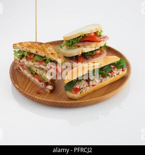 Getoastetes Sandwich, Club Sandwich und Thunfisch salat Brötchen auf Holzplatte Stockfoto