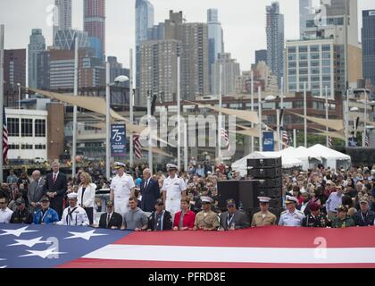 NEW YORK (28. Mai 2018) Von links, Bruce Mosler, Intrepid Museum Co-vorsitzender; Bürgermeister von New York, Bill De Blasio; Susan Marenoff-Zausner, Intrepid Museum Präsident; Adm. Christopher Grady, Commander, US-Flotte Kräfte und Mel Immergut, Intrepid Museum Stellvertretender Vorsitzender watch US-Mitglieder und Veteranen entfalten eine amerikanische Flagge zu einem Memorial Day Feier auf der Intrepid Sea, Air & Space Museum in New York City während der Fleet Week New York 2018. Jetzt in seinem 30. Jahr, Fleet Week New York ist die Stadt der altehrwürdige Feier auf das Meer. Es ist eine einmalige Chance für die citize Stockfoto