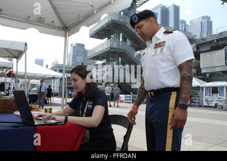 Master Sgt. David Foster (rechts), eine hohe Anzahl von Besuchern an die US-Armee Korps der Ingenieure von North Atlantic Division stand pierside Auf der USS Intrepid während New York City's Flotte Woche 2018 am 26. Mai. Stockfoto