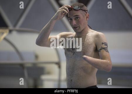 Us Marine Corps Cpl. Thomas Gilman Einstellen seiner Schutzbrille während einer 2018 DoD Krieger spiele Schwimmen Praxis am Cheyenne Mountain High School in Colorado Springs, Colo., 25. Mai 2018. Der Krieger Spiele ist eine adaptive Sport Wettbewerb für die Verwundeten, Kranken und Verletzten service Mitglieder und Veteranen. Stockfoto