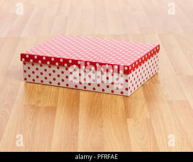Spotty box auf Holzboden Stockfoto