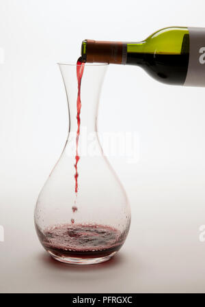 Gießen Rotwein aus Flasche in Glas Karaffe Stockfoto