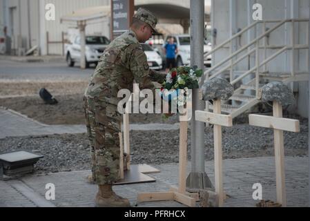 Air Force Tech. Sgt. Jonathan Robles, 380 Air Expeditionary Ehrengarde NCOIC, legt einen Kranz während des Memorial Day retreat Zeremonie am 380. Air Expeditionary Wing, 28. Mai 2018. Die Zeremonie alle gefallenen Service Mitglieder mit einer Flagge in den Ruhestand Zeremonie und Worte von Leadership geehrt. Stockfoto