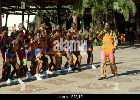 Durban, KwaZulu-Natal, Südafrika, erwachsenen Mann im Kostüm führende Gruppe von Straßenkünstlern, traditionellen Zulu Lied und Tanz, Gesang Truppe Stockfoto