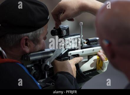 Kevin Nanson von Team Kanada macht Anpassungen sein Gewehr mit Hilfe von seinem Trainer während eines DoD Krieger Spiele üben, 30. Mai 2018, in der Air Force Academy in Colorado Springs, Colorado. Der Krieger Spiele sind eine jährliche Veranstaltung, 2010 gegründet, Verletzten, Kranken und Verletzten service Mitglieder auf adaptive Sport als Möglichkeit, ihre Genesung und Rehabilitation zu verbessern. Stockfoto