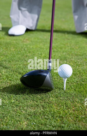 Golf Club auf Gras neben Golf Ball auf T-Stück Stockfoto