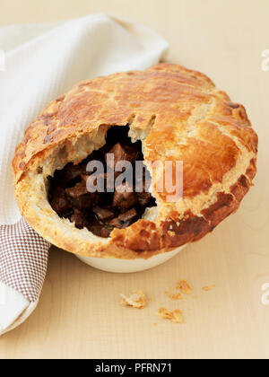 Steak, Pilz, und Ale mürbteig Gebäck Torte auf Holztisch mit Geschirrtuch, close-up Stockfoto