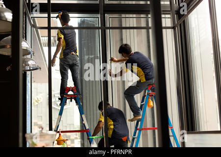 Nicht identifizierte Arbeitnehmer Anwendung gefärbten auf Glas Fenster Stockfoto