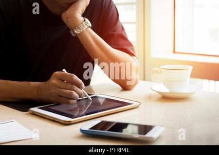 Innenarchitektur Mann bei der Arbeit auf Tablet mit Kaffeetasse und Zelle p Stockfoto