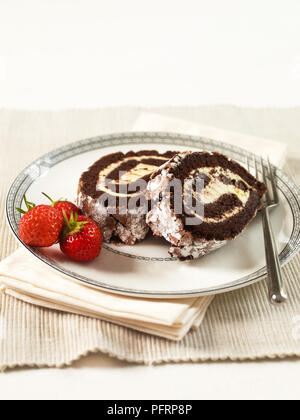 Schokolade Roulade, zwei Scheiben auf einen Teller, mit Erdbeeren garnieren Stockfoto