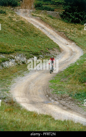 Mann reiten Mountainbike auf S-bend auf Feldweg Stockfoto