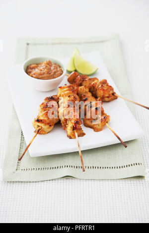 Chicken Satay mit Erdnuss-Sauce und Kalk Keile Stockfoto