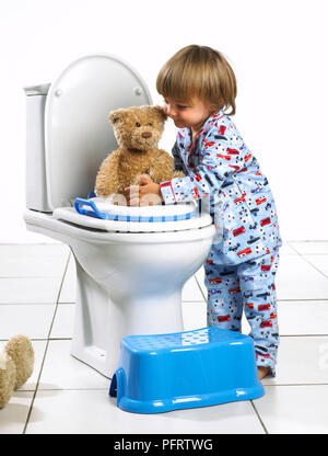 Toddler boy Holding Teddybär auf Wc, 1,5 Jahre Stockfoto