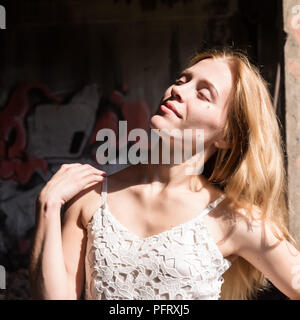 Lonely blondy Frau in einem whit transparente Bluse in verlassenen Gebäude Stockfoto