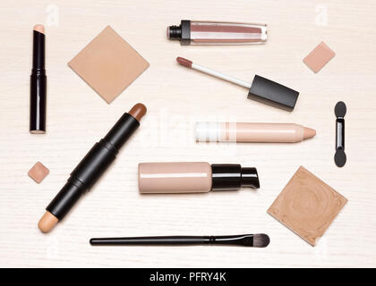 Basic Make-up-Produkte: Primer, Concealer, Liquid Foundation, kosmetische Gesichts Puder auf hellem Holz Tisch, flach Stockfoto