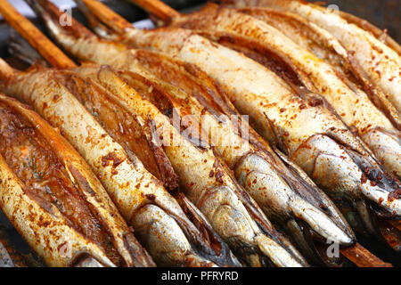 Nahaufnahme Kochen mehrere bonito Makrele fischen auf Holz Spieß Grill, hohe Betrachtungswinkel Stockfoto