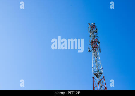 Rote und weiße Turm von Kommunikation mit mit vielen verschiedenen Antennen unter klaren Himmel. Telecom Signal Tower. Fernmeldeturm Zellen für mobile kommunikation. raum Kopieren Stockfoto