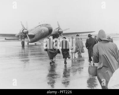 1950er Jahre Urlaub. Eine Gruppe von Menschen gehen in den strömenden Regen auf die wartende Flugzeug für Spanien gebunden. Schweden 1951. Ref 385 Stockfoto