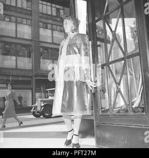 Frau aus den 1940er Jahren im Regenmantel. Eine junge Frau in einem Regenmantel aus Kunststoff. Schweden 1946 Ref. V112-6 Stockfoto