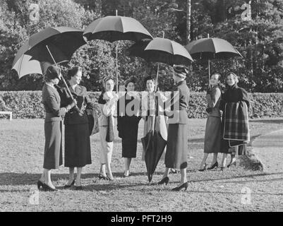 Sonnenschirme in den 1950er Jahren. Eine Gruppe von modisch gekleideten Frauen sind zusammen mit vier Schirme. Sie sind Schülerinnen und Schüler der Modeschule Märthaskolan in Stockholm, wo sie höhere Bildung in der Damenmode. Die Schule ist benannt nach der schwedischen Prinzessin Märtha. Schweden 1954 Stockfoto