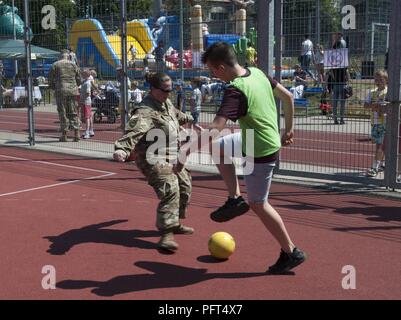 Us-Armee Maj. Emily Lynds, Personal Offizier zu entschlossenem Schloss 18 zugeordnet, 218 Manöver Verbesserung Brigade, South Carolina Army National Guard, spielt Fußball gegen eine Studentin aus Boleslawiec Grundschule Nr. 4 während ihrer Schule Festival in Boleslawiec, Polen, 26. Mai 2018. Resolute Schloss Soldaten wurden besondere Gäste des Festivals und in Sportveranstaltungen und Töpferei, Malerei mit der Grundschule Kinder teilgenommen. Stockfoto