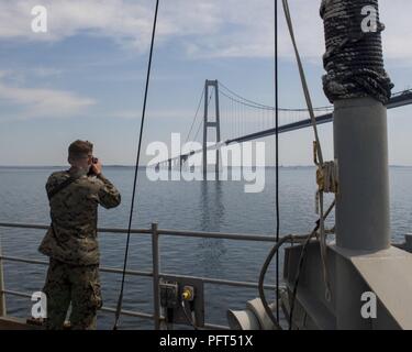 Straße (29. Mai 2018) der US-Marine Cpl. Colby Livingston Fotografien die feste Verbindung über den Großen Belt, dritte längste Hängebrücke der Welt, an Bord der Harpers Ferry-Klasse dock Landung Schiff USS Oak Hill (LSD 51), überträgt es die Dänische Straße 29. Mai 2018. Oak Hill, homeported in Virginia Beach, Virginia, ist die Durchführung von naval Operations in den USA 6 Flotte Bereich der Operationen. Stockfoto