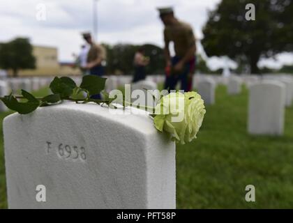 Us-Marines statt Blumen auf Grabstätten der Gefallenen service Mitglieder während einer Volkstrauertag Kranzniederlegung am Hampton National Cemetery in Hampton, Virginia, 28. Mai 2018. Die Teilnehmer werden Hunderte von Blumen auf Grabstätten auf dem Friedhof auf gefallen Service Members' Opfer zu reflektieren. Stockfoto