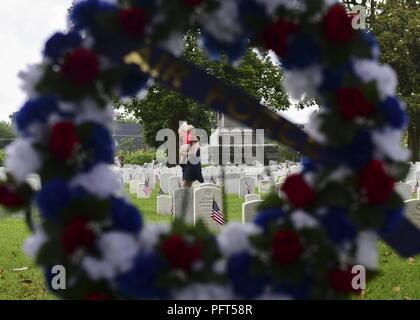 Jennifer Seeder, Militär Ehepartner, trägt ihr Sohn, Knäuel, 1, Blumen auf die Gräber Service Members' nach einem Volkstrauertag Kranzniederlegung am Hampton National Cemetery in Hampton, Virginia, 28. Mai 2018. Zeremonie Teilnehmer legten Hunderte von Blumen auf dem Friedhof gefallen Service Members' Erinnerungen zu ehren. Stockfoto