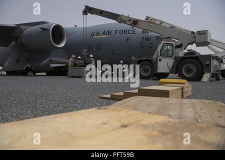 Betreuer aus dem 5 Expeditionary Air Mobility Squadron Austauschen einer Auxiliary Power Unit auf einer C-17 Globemaster III von der gemeinsamen Basis Charleston, S.C. an einem geheimen Ort im Südwesten Asien. Zwei Kräne wurden eingesetzt, um die schwere Ausrüstung zu bewegen. Stockfoto