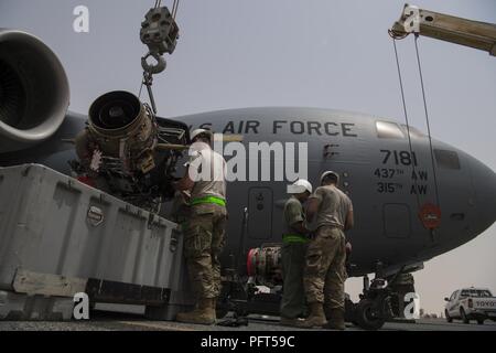 Betreuer aus dem 5 Expeditionary Air Mobility Squadron Austauschen einer Auxiliary Power Unit auf einer C-17 Globemaster III von Charleston, S.C. an einem geheimen Ort im Südwesten Asien, 31. Mai 2018. Zwei Kräne wurden eingesetzt, um die schwere Ausrüstung zu bewegen. Stockfoto