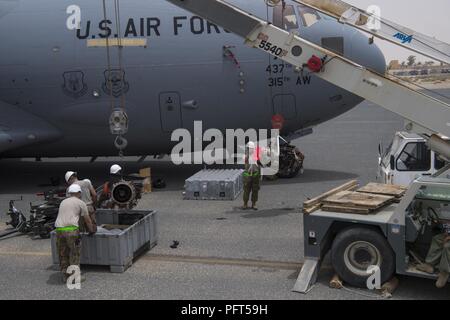 Betreuer aus dem 5 Expeditionary Air Mobility Squadron Austauschen einer Auxiliary Power Unit auf einer C-17 Globemaster III von Charleston, S.C. an einem geheimen Ort im Südwesten Asien, 31. Mai 2018. Zwei Kräne wurden eingesetzt, um die schwere Ausrüstung zu bewegen. Stockfoto