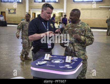 Us-Soldaten, Flieger und Mitarbeiter in die South Carolina National Guard teilnehmen, um die Sicherheit und die Gesundheit am Arbeitsplatz fair Bei Bluff Road Waffenkammer in Columbia, South Carolina, 1. Juni 2018. Derrec Becker, Chief Information der Öffentlichkeit und Externe Angelegenheiten Südcarolina Emergency Management Division, zeigt die neue Notfallvorsorge App für Smartphones Geräte. Die Veranstaltung wirft das Bewusstsein für Fragen der Sicherheit Arbeitssicherheit Ausbildung zu fördern. Stockfoto