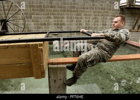 Us Air Force Senior Airman Nick Benson, ein Spezialist für die Sicherheitskräfte 180 Fighter Wing, Ohio Air National Guard zugewiesen ist, zieht ein Warenkorb über ein wasserhindernis nach, im Fallen auf den ersten Versuch, 21. Mai 2018, an der Führung Reaktion Kurs an Ft. Custer, Michigan. Zusammenarbeit in kleinen Gruppen, die Flieger gedreht über mehrere Stationen, für den Transport eines 50-Gallone Trommel- oder 40-Pfund Munition, nur mit Seilen oder Bretter, über verschiedene Hindernisse. Stockfoto