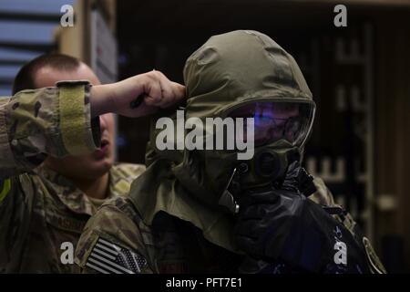 15 Special Operations Squadron aircrew Mitglied ist mit seinem bodenpersonal in die Augen- und Atemschutz, das während der großen Kampfhandlungen Übung an hurlburt Field, Fla., 23. Mai 2018 unterstützt. Mitglieder der 1 Special Operations Wing richtig genutzt Mission Oriented schützende Haltung Gang und den sich verändernden Bedrohung reagiert während der mcoe Angriff - Antwort bereit zu halten. Stockfoto