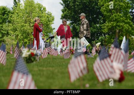 Mitglieder der Gemeinschaft anhalten, um ihren Respekt zu zu vielen der Grabstätte von begraben Veteranen nach dem Memorial Day Programm am Willamette National Cemetery, Portland, Oregon, 28. Mai 2018 statt. (National Guard Stockfoto