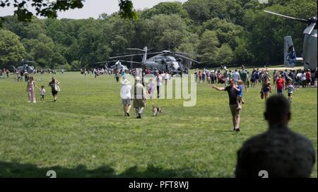 Ein Marine Uhren als Zivilisten im Static Display Flugzeuge während der Fleet Week New York am Prospect Park in Brooklyn, N.Y., 26. Mai 2018. Die Marines in New York wurden mit der Öffentlichkeit zu kommunizieren, sich Fähigkeiten demonstrieren und die Leute von New York über America's Sea Services während der Flotte Woche unterrichten. Stockfoto