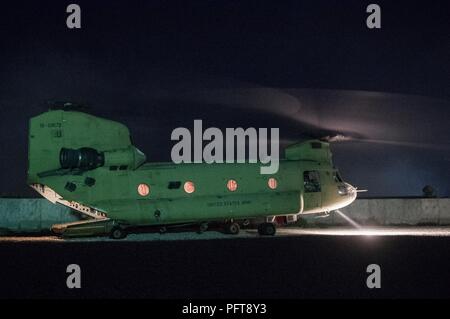 Bezirk Garmsir, Afghanistan (31. Mai 2018) - ein US-Army CH-47 Chinook erwartet Ladung bei einer Landing Zone in der Nähe von Bezirk Garmsir, Afghanistan, 31. Mai 2018. Die Chinooks Neuversorgung der benötigten Güter zu kargen Umgebungen, wie Deh Bala Bezirk ermöglichen, Nangarhar Province, Afghanistan, wo afghanische Commando und US-Spezialeinheiten sind derzeit die Durchführung von offensive Operationen gegen ISIS-K. Die größte kombinierte Kontingent der Afghanischen Kommandos immer montiert, durch die US-Special Forces geraten begann Routing ISIS-K aus dem Bezirk am 28. Mai 2018. Stockfoto