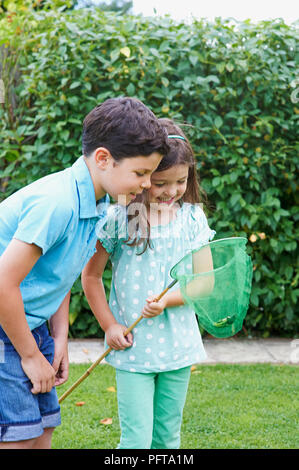 Junge und Mädchen an Frosch im Fischernetz suchen Stockfoto