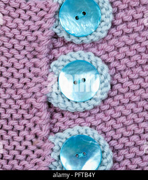 Blaue Tasten auf lila Gestrickte Jacke Stockfoto