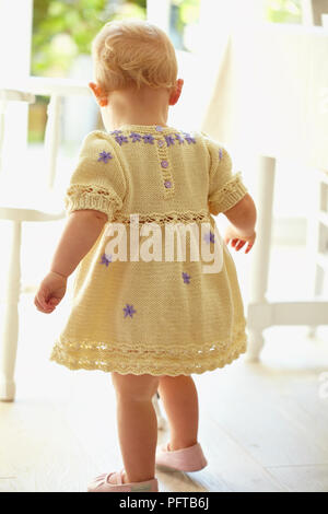 Baby Mädchen heraus treten in gelb Strickkleid 17 Monate Stockfoto