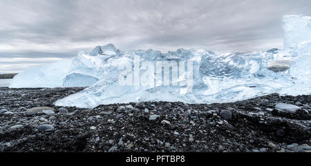 Ein Eisberg gewaschen oben auf einem schwarzen Sandstrand in Island. Stockfoto