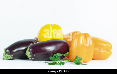 Paprika, Auberginen und Zweige Petersilie auf einem weißen backgroun Stockfoto