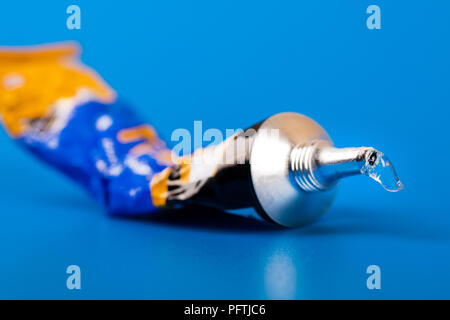 Sekundenkleber tube auf blauem Hintergrund Stockfoto