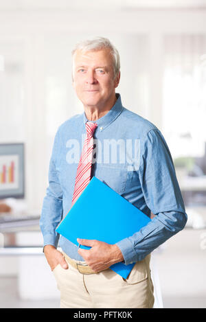 Porträt eines Senior Financial Consultant ständigen Holding Dokument in der Hand, während man im Büro. Stockfoto