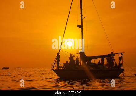 Segelboot Sonnenuntergang fantasy mit einem Silhouettiert Boot segeln entlang der Reise gegen eine leuchtend bunte Sonnenuntergang Stockfoto