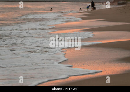 Sonnenuntergang an Strand, Meer Ozean starke Farben, Layer, kleine Wellen auf Sand Stockfoto